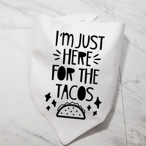 Op de afbeelding: Witte katoenen bandana met zwarte tekst die "Ik ben hier alleen voor de taco's" zegt en een zwart-witte illustratie van een taco.