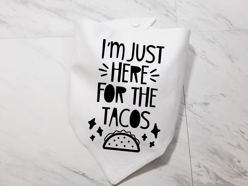 Op de afbeelding: Witte katoenen bandana met zwarte tekst die "Ik ben hier alleen voor de taco's" zegt en een zwart-witte illustratie van een taco.