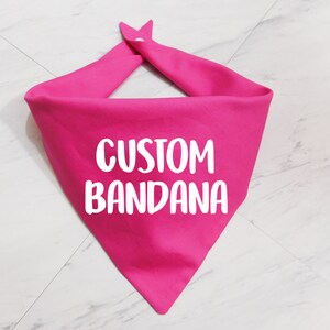 May include: A pink bandana with the text "CUSTOM BANDANA" in white.