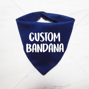 May include: A navy blue bandana with the text "CUSTOM BANDANA" in white.