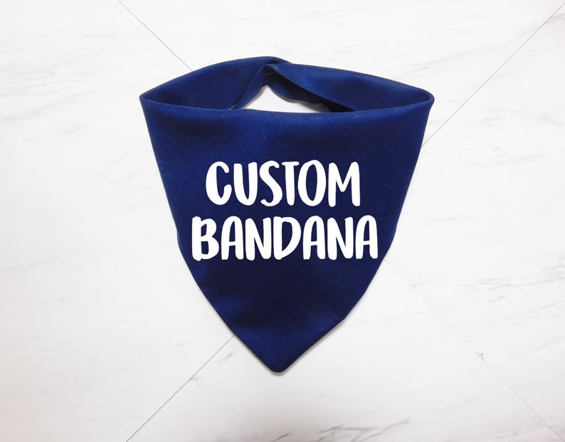 May include: A navy blue bandana with the text "CUSTOM BANDANA" in white.
