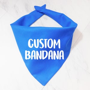 May include: A bright blue bandana with the text "CUSTOM BANDANA" printed in white.