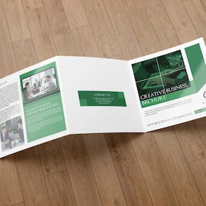 Könnte beinhalten: Eine dreifach gefaltete Broschüre in Weiß und Grün mit Texten wie "ABOUT US", "CONTACT US" und "CREATIVE BUSINESS BROCHURE". Das Layout zeigt Fotos von Personen in einer Büroumgebung sowie Platzhaltertext für den Inhalt der Broschüre.