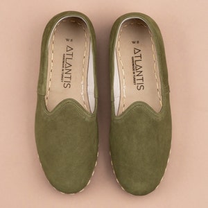 Pu&ograve; includere: Un paio di scarpe da uomo in camoscio verde da indossare senza lacci con un'etichetta "W 8 ATLANTIS HANDMADE IN TURKEY" all'interno.
