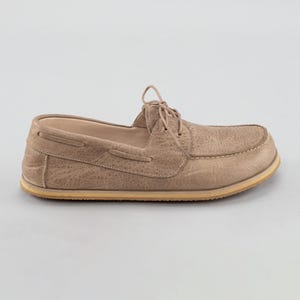 Pu&ograve; includere: Una singola scarpa da barca beige con tomaia in pelle strutturata e suola colorata chiara. La scarpa presenta una chiusura con lacci e dettagli di cucitura visibili. Il design generale &egrave; casual e adatto all'uso quotidiano.