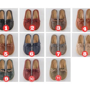 Pu&ograve; includere: Una collezione di undici paia di mocassini in pelle in vari colori, tra cui nero, rosso, marrone, blu navy, grigio e beige. Ogni paio presenta una punta arrotondata, un fiocco decorativo e il marchio "FATLANDIS" stampato sulla soletta.