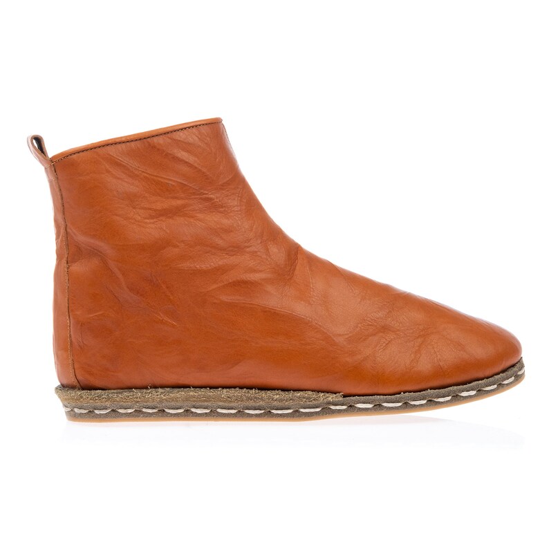 May include: A pair of brown leather ankle boots with a white stitched sole. The boots have a simple design and a rounded toe.