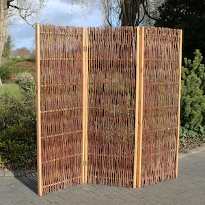 May include: A three-panel room divider made of woven willow branches. The panels are connected by hinges and stand on wooden frames. The divider is a natural brown color.