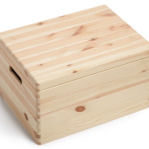May include: A rectangular wooden storage box with a lid. The box is constructed from light-colored, unfinished wood planks. It features a handle cut-out on one side and is suitable for storing various items. The box is designed with a simple, natural aesthetic.