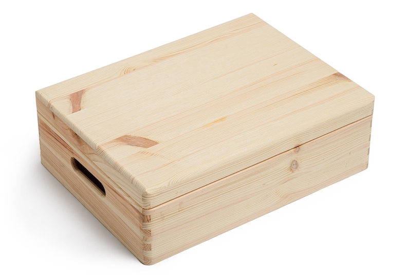May include: A rectangular wooden box with a lid, constructed from light-colored pine. The box features a handle cutout on one side and is assembled with visible dovetail joints. The wood grain is prominent, and the box appears to be unfinished.