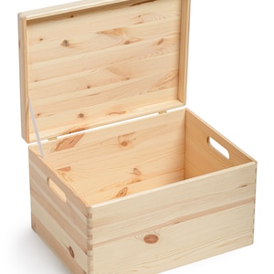 May include: An open, light-colored wooden storage box with a hinged lid. The box has a rectangular shape with finger-jointed corners and cut-out handles on the sides. The lid is partially open, revealing the interior.