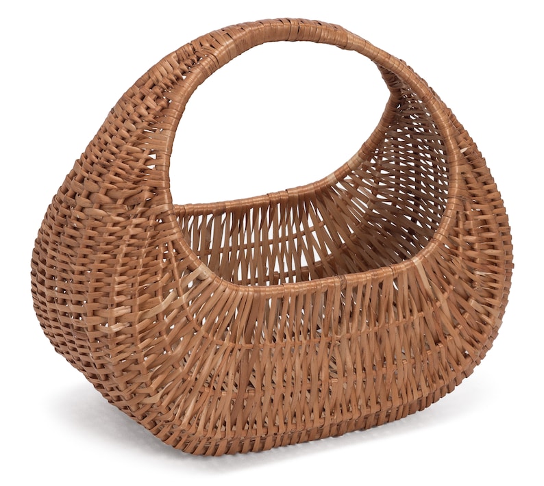 May include: A brown wicker basket with a handle. The basket is oval shaped and has a woven pattern.