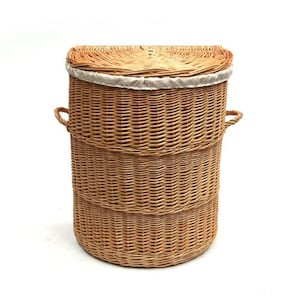 May include: A natural woven wicker laundry basket with a white fabric liner and two handles. The basket is oval shaped and has a natural brown color.