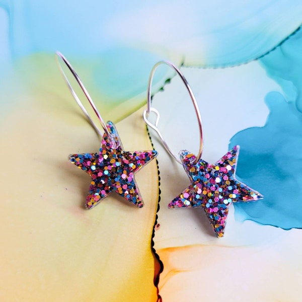 Handmade glitter resin star charms on silver plated hoop earrings, pink blue and gold glitter