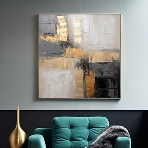 Puede incluir: Pintura al óleo abstracta en un marco dorado. La obra presenta una superficie texturizada con pinceladas doradas, grises, negras y blancas. Un sillón turquesa con una manta gris y un jarrón dorado están en primer plano.