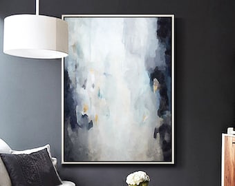 May include: Abstract painting with shades of blue, white, and gray. The painting is framed and hanging on a dark gray wall in a living room setting.