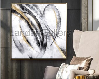 May include: Abstract art piece with a gold frame. The artwork features black, white, and gold brushstrokes. The text "LandaGallery" is visible in the lower left corner. The painting is displayed above a gray armchair with decorative pillows.