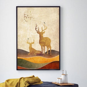 May include: A framed print with a vintage aesthetic featuring two golden deer silhouettes against a textured background of brown, green, and yellow hills. Small blue birds are perched on the deer's antlers and flying in a circle above them.