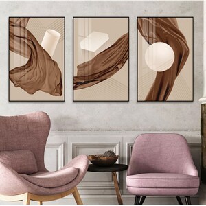 K&ouml;nnte beinhalten: Drei abstrakte Kunstdrucke mit braunem Stoff und geometrischen Formen in Wei&szlig;. Der Stoff flie&szlig;t und die Formen sind einfach und modern.