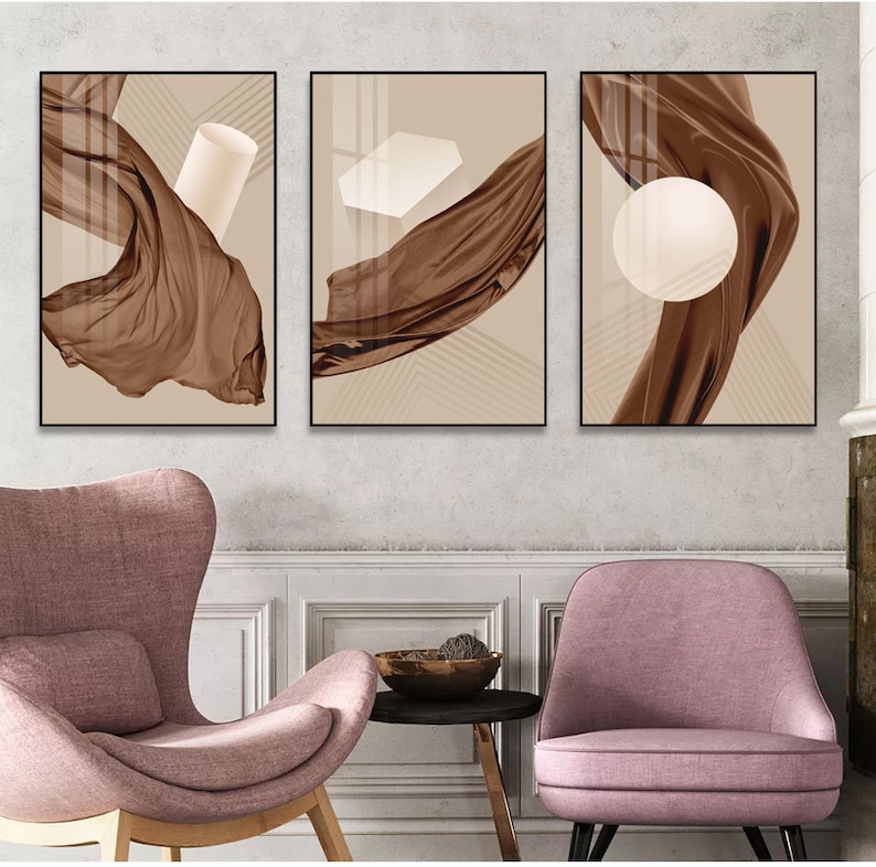 K&ouml;nnte beinhalten: Drei abstrakte Kunstdrucke mit braunem Stoff und geometrischen Formen in Wei&szlig;. Der Stoff flie&szlig;t und die Formen sind einfach und modern.