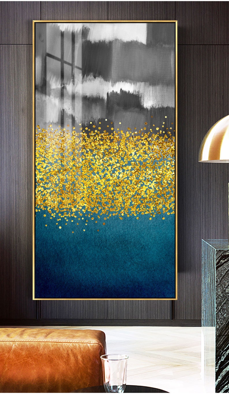 May include: Abstract art print with a gold glitter design on a blue and gray background. The print is framed in a gold frame.