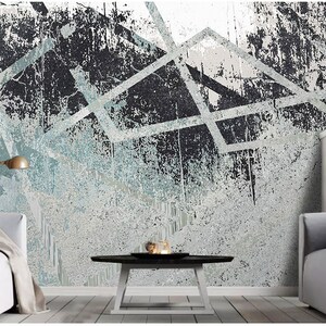 May include: Abstract geometric wall art with a distressed, textured background in shades of grey and blue. The design features white lines and shapes creating a modern and edgy look.