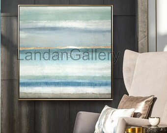 May include: Abstract painting with horizontal stripes in shades of blue, green, and white. The painting has a gold stripe in the middle and is framed in a gold frame.