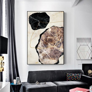 Op de afbeelding: Abstracte kunstprint met twee onregelmatige marmervormen, een zwarte en een bruine met gouden aderen, op een witte achtergrond met gouden lijnen.