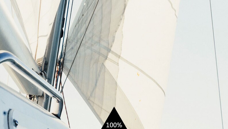 Puede incluir: Una vista cercana del m&aacute;stil y la vela de un velero, con la vela ondeando en el viento. La vela es blanca y el m&aacute;stil es plateado. La imagen se toma desde un &aacute;ngulo bajo, mirando hacia arriba a la vela.