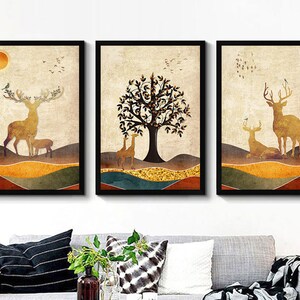 May include: A set of three framed prints featuring a stylized illustration of a forest scene with deer and a tree. The prints have a vintage aesthetic with a muted color palette of browns, yellows, and greens.