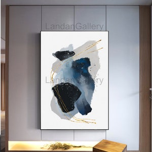 Peut inclure: Impression d'art abstrait avec des formes d'aquarelle bleues et noires et des lignes dor&eacute;es sur un fond blanc. L'impression est encadr&eacute;e et accroch&eacute;e &agrave; un mur.