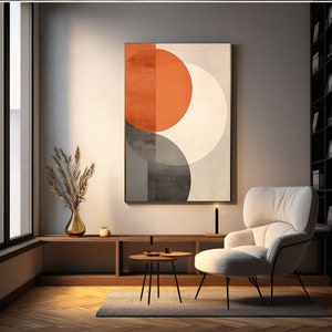 Può includere: Arte da parete geometrico astratto con un grande cerchio arancione, un cerchio bianco più piccolo e un cerchio grigio. L'opera d'arte è incorniciata da una sottile cornice dorata e appesa a una parete grigio chiaro.