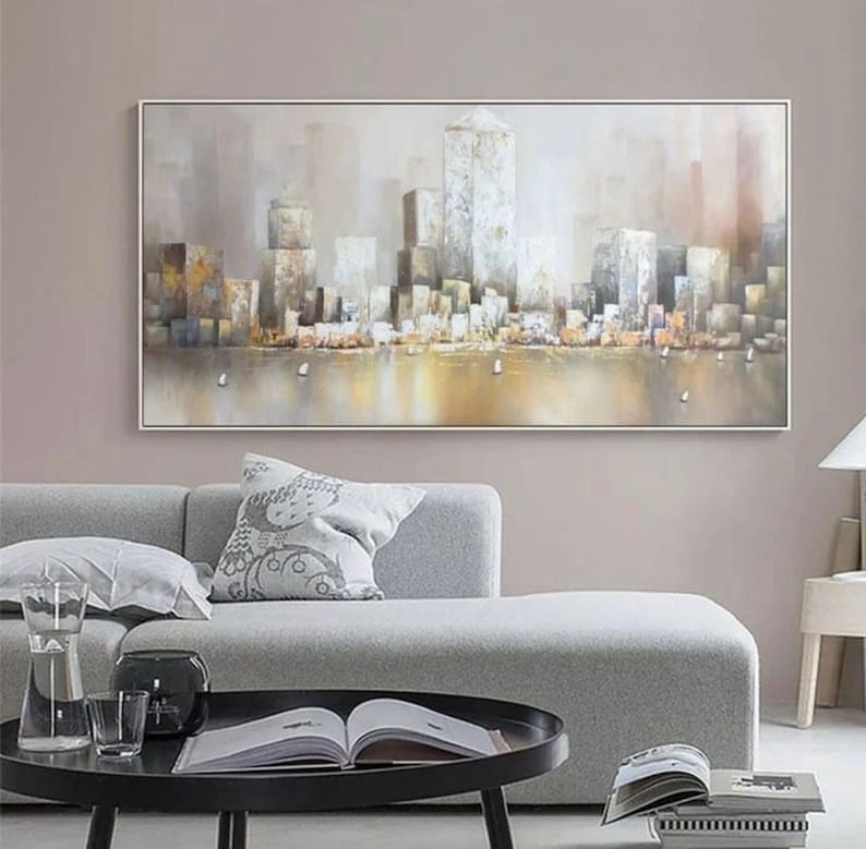 Puede incluir: Una pintura de un paisaje urbano con edificios altos en tonos grises y marrones. Los edificios se reflejan en el agua en primer plano, que es de color dorado claro. El cielo es de color gris claro.