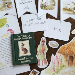 Puede incluir: Una colección de recortes de fieltro de colores y tarjetas de papel con ilustraciones del libro infantil "The Tale of Jemima Puddle-Duck" de Beatrix Potter. La portada del libro también se incluye en la imagen.