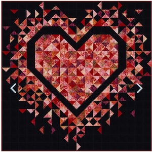 May include: A quilt with a large heart shape in the center, made of red, pink, and orange fabric. The heart is surrounded by smaller triangles of the same colors, creating a burst effect. The background is black.