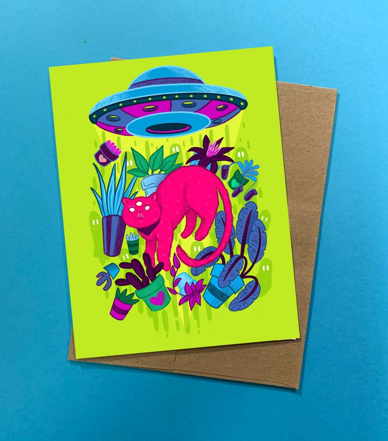 May include: A pink cat with three eyes stands in a green field of plants. A flying saucer hovers above the cat, casting a beam of light down on the scene. The cat is surrounded by various plants in pots, including a cactus, a fern, and a succulent.