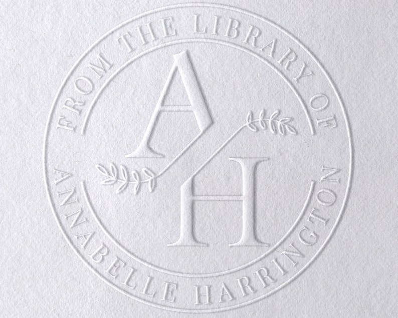 May include: A white embossed circle stamp with the text "From the Library of Annabelle Harrington" and the initials "AH" with a leafy design.