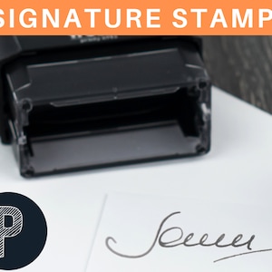 May include: A black self-inking signature stamp with a clear ink pad. The stamp is on a white surface with a handwritten signature and a black circle with a white letter "P" inside.