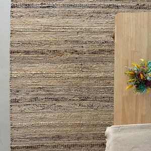 A stylish hallway decorated with a long, durable jute rug runner in natural and cream tones plus black