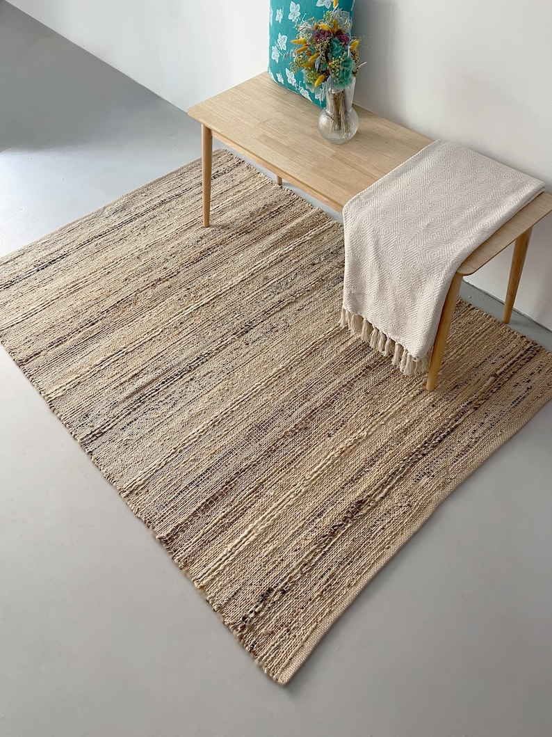 A large, natural farmhouse jute rug with black stripes, adding charm and durability to a living room