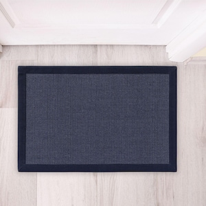 Peut inclure: Un paillasson bleu foncé avec une bordure noire. Le paillasson est fait d'un matériau texturé et est conçu pour être placé devant une porte.