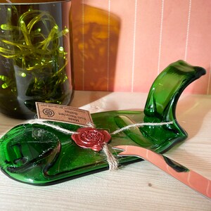 May include: A green glass serving dish made from recycled bottles with a small knife and a wax seal that says "Made from Recycled Bottles GreenWood Creations".