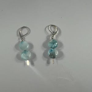 May include: A pair of silver earrings with blue and white gemstone beads.