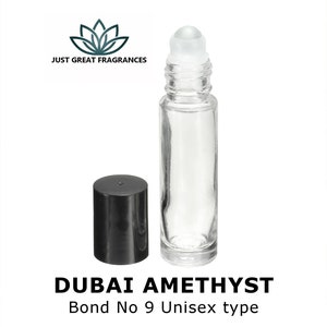 May include: A clear glass roll-on bottle with a black cap. The bottle is filled with a clear liquid. The bottle is labeled "DUBAI AMETHYST Bond No 9 Unisex type".