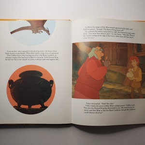 May include: An open book with illustrations from a children's story. One page shows a black cauldron in an orange circle, and a dragon. The other page depicts two characters in a room. Text is visible on both pages.