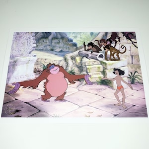 May include: A colorful print featuring characters from Disney's The Jungle Book. The image shows a large brown orangutan with outstretched arms, a young boy in orange briefs, and several monkeys. The background includes stone structures and lush foliage.