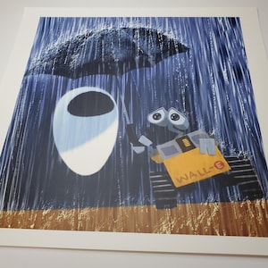 May include: A print featuring the characters Wall-E and Eve from the animated film. Wall-E, a yellow robot, holds an umbrella over Eve in the rain. The background is a dark blue with rain streaks, and the print has a white border.