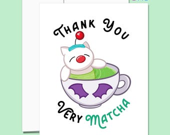 Puede incluir: Tarjeta de felicitación blanca con una ilustración de dibujos animados. La imagen presenta una criatura blanca con una nariz roja y una cereza en la cabeza, relajándose en una taza de líquido verde. Las palabras "Thank You" y "Very Matcha" están escritas en la tarjeta.