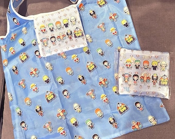 May include: A blue reusable shopping bag with a white trim and a repeating pattern of cartoon characters. The bag has a pocket on the front with a white background and a similar pattern of cartoon characters. The bag is made of a thin, lightweight material.