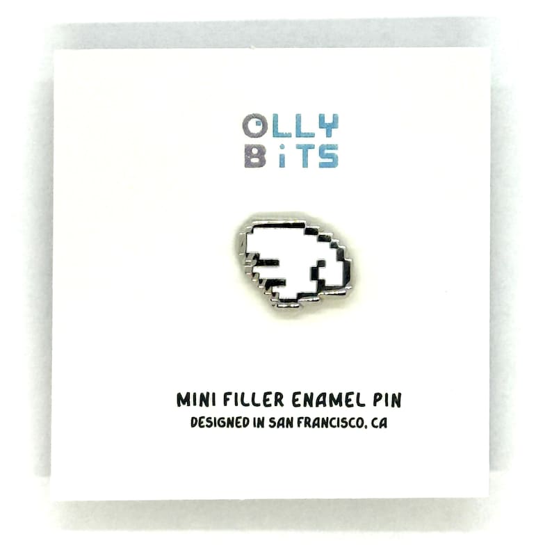 Puede incluir: Una tarjeta blanca con el texto "OLLY BITS" en gris y azul. Un pin plateado con forma de mano pixelada est&aacute; centrado en la tarjeta. El texto "MINI FILLER ENAMEL PIN DESIGNED IN SAN FRANCISCO, CA" est&aacute; debajo.